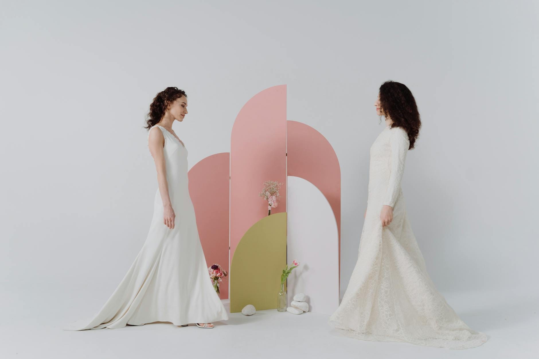 Dwie kobiety w eleganckich sukienkach w minimalistycznym studiu