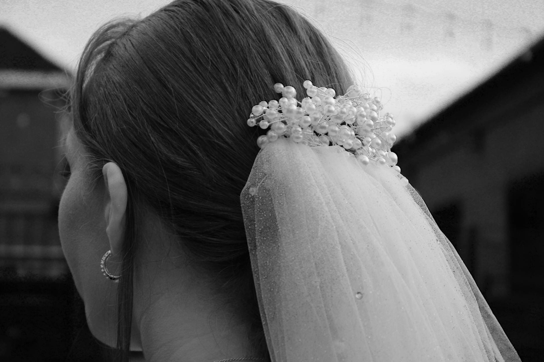Panna młoda od tyłu z welonem i ozdobnymi koralikami w czerni i bieli