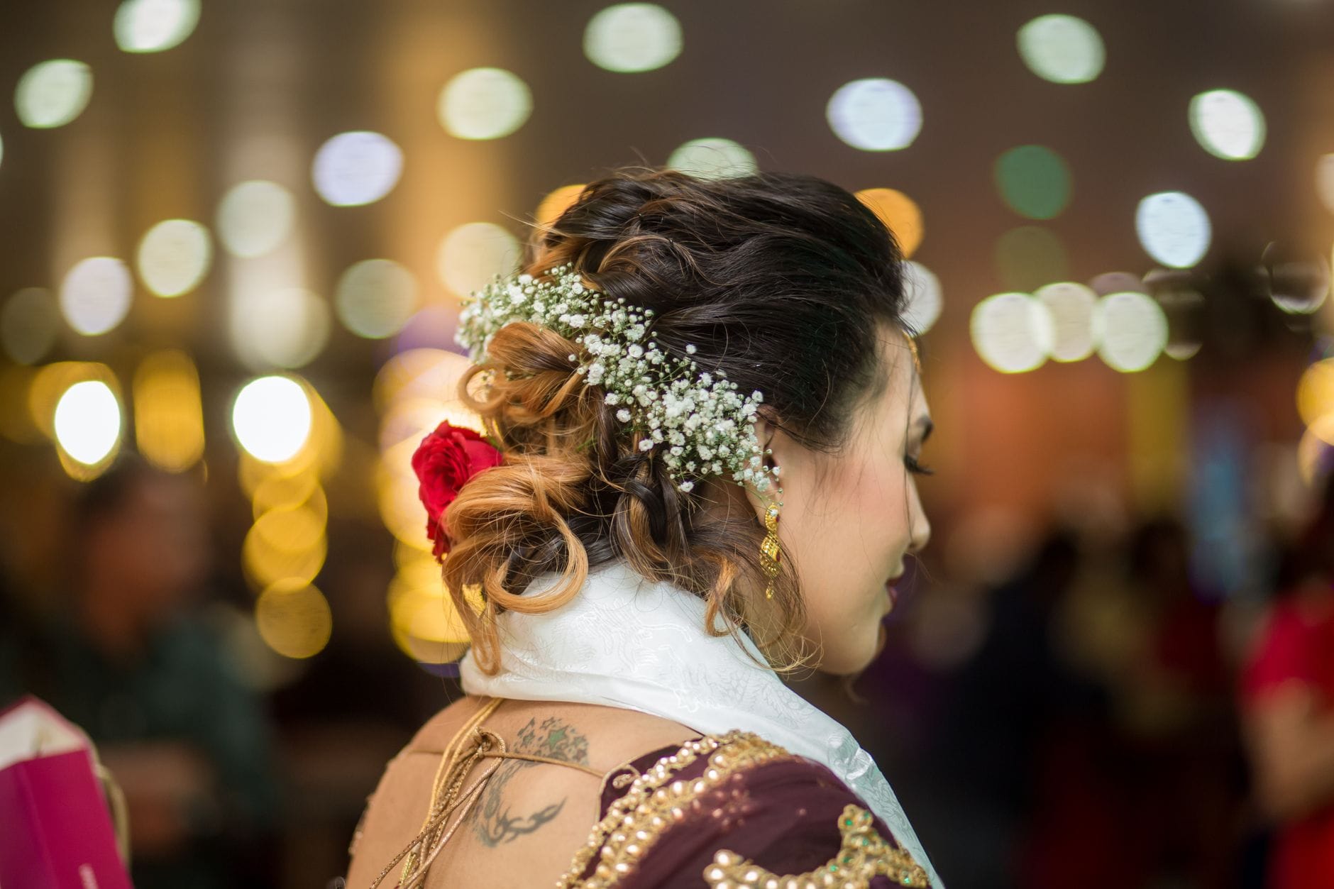 Panna młoda z upiętymi włosami, kwiatami i eleganckimi kolczykami